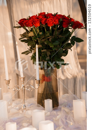 Romantic Red Roses Bouquet with Candles: Luxurious Valentine's Day Still Life, Dark Mood, Silver Accents, and Soft Lighting. Romantic Red Roses Bouquet with Candles: Luxurious Valentine's Day Still Life, Dark Mood, Silver Accents, and Soft Lighting. 132504019