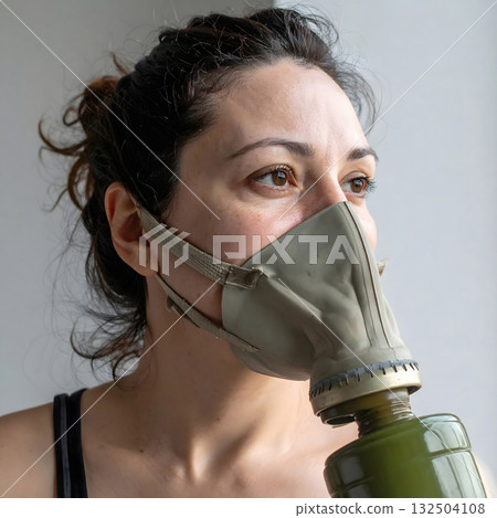 Woman with old gray gas mask and green filter Woman with old gray gas mask and green filter 132504108