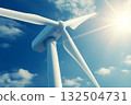 Close up of wind turbine under blue sky and bright sun 132504731