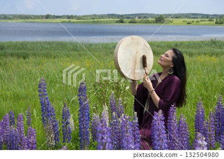 Female shaman drumming among the flowers Female shaman drumming among the flowers 132504980