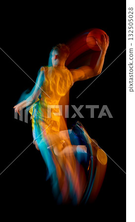 Basketball player in yellow sportswear jumping with ball and colorful motion streaks 132505028