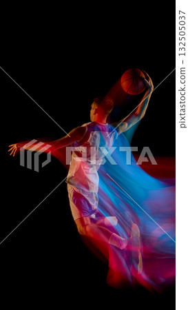 Basketball player jumping high holding ball with red and blue motion light on dark background Basketball player jumping high holding ball with red and blue motion light on dark background 132505037