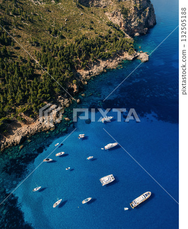 Aerial view of boats floating on crystal clear blue water Aerial view of boats floating on crystal clear blue water 132505188