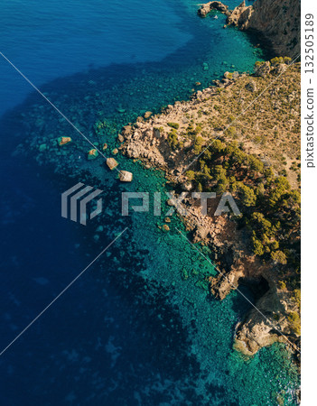 Aerial view of rugged coastline with turquoise water Aerial view of rugged coastline with turquoise water 132505189