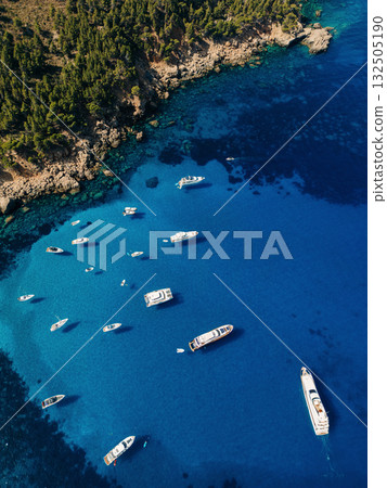 Aerial view of boats floating on crystal clear blue water Aerial view of boats floating on crystal clear blue water 132505190