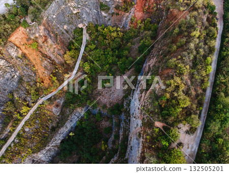 Aerial view of rocky canyon cliffs with winding paths 132505201