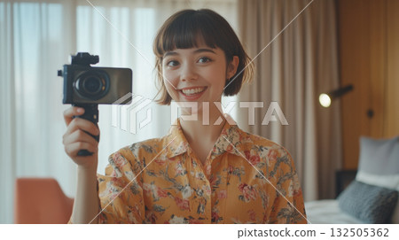 Smiling influencer recording video in bright modern home 132505362