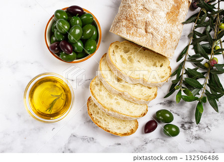 appetizer, sliced ciabatta bread, with olive oil, green olives, Chalkidiki olives, classic Green green olive, on a marble table, top view, no people, appetizer, sliced ciabatta bread, with olive oil, green olives, Chalkidiki olives, classic Green green olive, on a marble table, top view, no people, 132506486