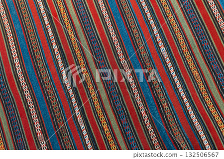 An old oriental carpet fabric with parallel colorful lines pattern, background photo 132506567