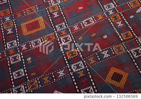 A vivid textile featuring a geometric grid of red and grey blocks 132506569