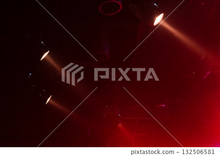 Energetic concert scene featuring red spotlights cutting through haze 132506581