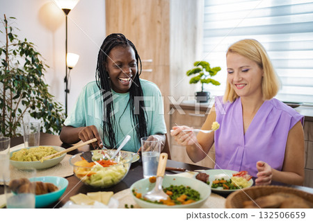 Two friends enjoying a delightful meal together at home 132506659