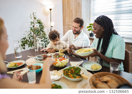 A joyful family meal together in a cozy dining room A joyful family meal together in a cozy dining room 132506665