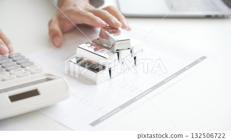 Silver Trading Businessman invest in trading silver, calculating price and monitoring online using smartphone. 132506722