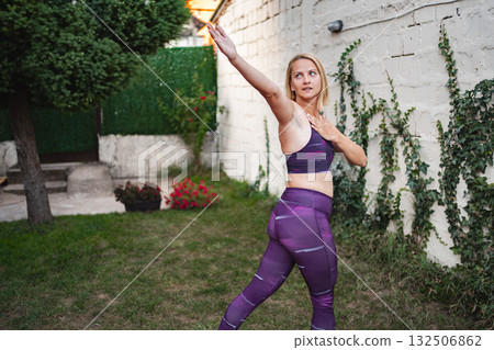 Mother rejuvenates her spirit through exercise in a serene backyard setting 132506862