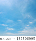 Atmospheric cloudscape featuring dense white clouds at bottom and scattered light clouds above in natural daylight 132506995