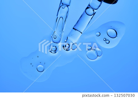 Pipettes with facial serum or other cosmetic product on a blue background. 132507030