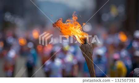 Bright Olympic torch flame blurs against a vibrant crowd during the torch relay event on a sunny day 132507391