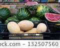 Melons and watermelons in outdoor market stall and juicy red watermelon cut in half. 132507560