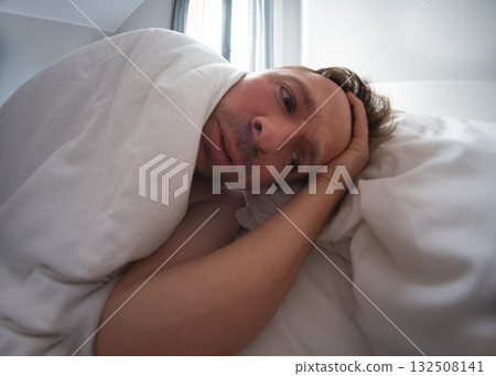 Man unable to sleep, lying awake and worrying about problems Man unable to sleep, lying awake and worrying about problems 132508141