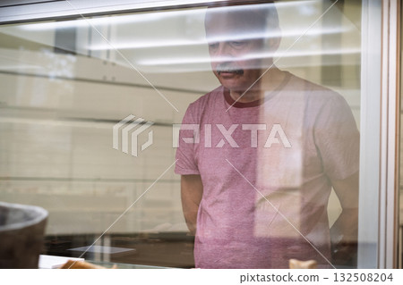 Elderly man looking at a display case in a museum 132508204
