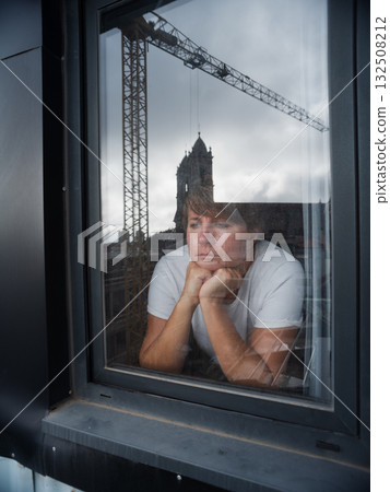 Woman thoughtfully looking out the window 132508212