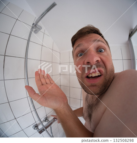 Man standing under a shower with no water, affected by water outage at home 132508298