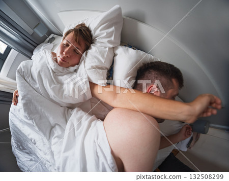 Woman accidentally disturbing her husband sleep by placing her hand on his face Woman accidentally disturbing her husband sleep by placing her hand on his face 132508299