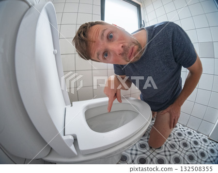 Man looking at a perfectly clean toilet, surprised by how well his wife cleaned it Man looking at a perfectly clean toilet, surprised by how well his wife cleaned it 132508355