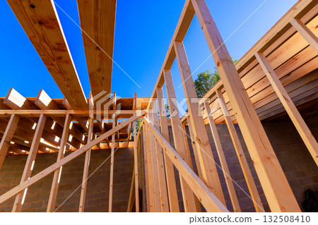 Wooden framing for house is with beams walls, under work day in construction site. 132508410