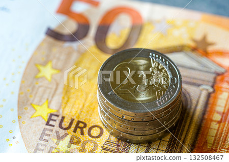 Stack of two euro coins on fifty euro banknote symbolizing European finance, money, and economy Stack of two euro coins on fifty euro banknote symbolizing European finance, money, and economy 132508467