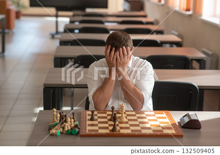 Middle aged Caucasian man playing chess.  132509405