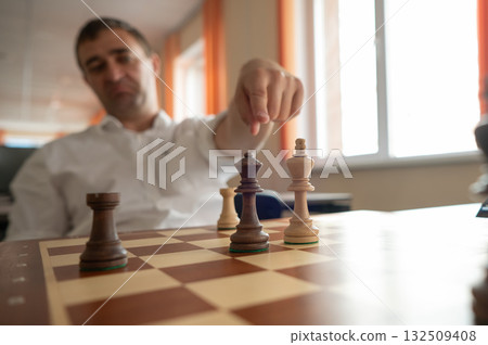 Middle aged Caucasian man playing chess.  132509408