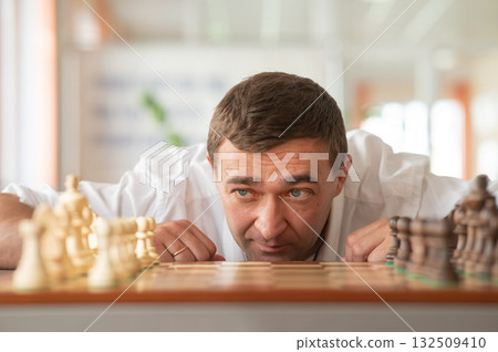 Middle aged Caucasian man playing chess. Middle aged Caucasian man playing chess. 132509410