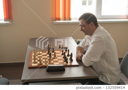 Middle aged Caucasian man playing chess.  132509414