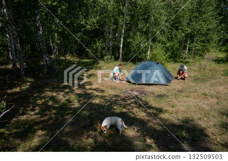 Caucasian man and woman pitching tent outdoors. Caucasian man and woman pitching tent outdoors. 132509503