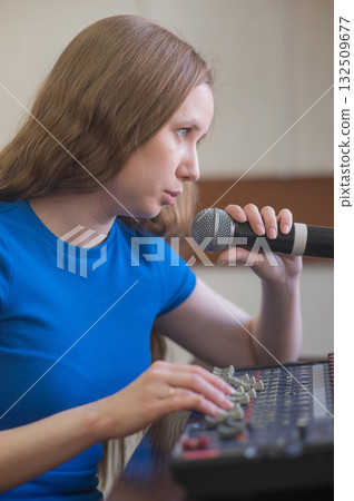 Young woman mixing live sound. Girl recording a song in the studio.  132509677