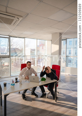Two Caucasian men solve problems at work. Two Caucasian men solve problems at work. 132509889
