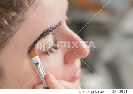 Caucasian woman getting eyebrow tinting procedure. Caucasian woman getting eyebrow tinting procedure. 132509914