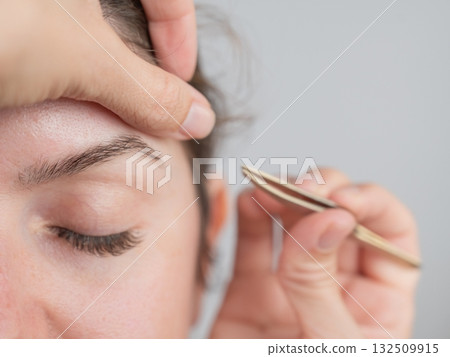 Caucasian woman undergoing eyebrow correction procedure.  132509915