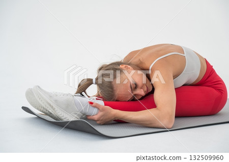 Caucasian woman doing stretching and doing side splits on white background. Caucasian woman doing stretching and doing side splits on white background. 132509960