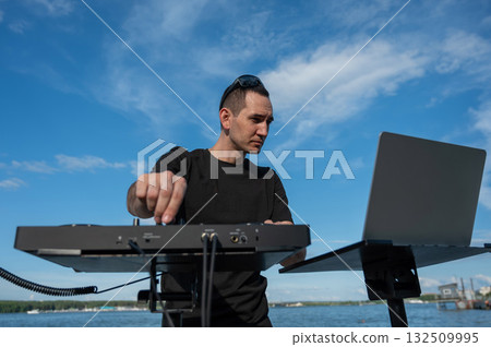 Male DJ playing music on the beach. Male DJ playing music on the beach. 132509995