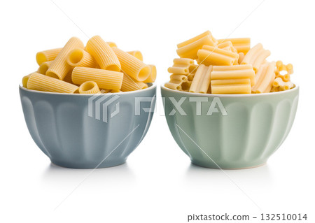 Cinque buchi and rigatoni. Uncooked italian pasta in bowl isolated on white background. 132510014
