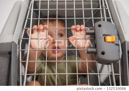 A small child in a closed cage. 132510086