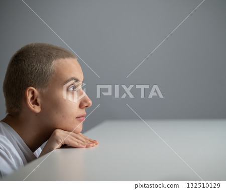 A Caucasian woman with short hair peeks out from under a table. A Caucasian woman with short hair peeks out from under a table. 132510129