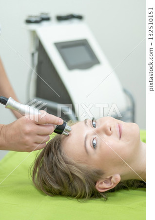 Caucasian woman undergoing radio wave RF lifting procedure in beauty salon.  132510151