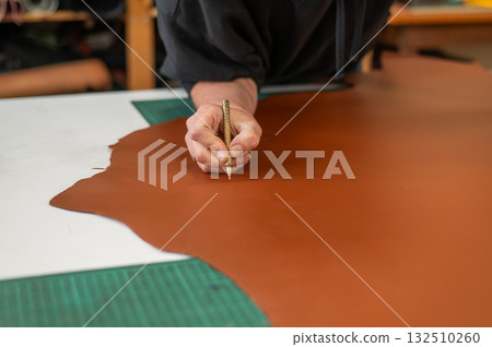 Caucasian bearded man working as a tanner in a workshop. Caucasian bearded man working as a tanner in a workshop. 132510260