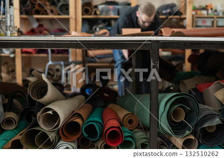 Caucasian bearded man working as a tanner in a workshop.  132510262