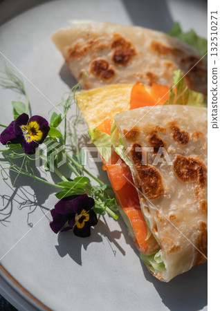 A flatbread stuffed with fish and cheese served in a cafe. Quesadilla. 132510271