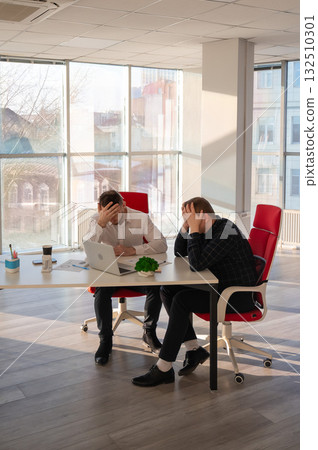 Two Caucasian men solve problems at work.  132510301